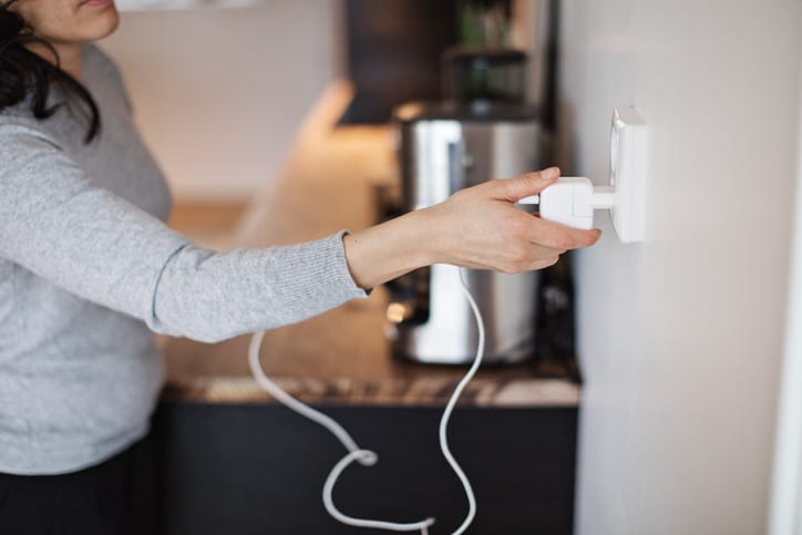 Palmetto Electrical Contractors | woman plugging in charger into wall outlet
